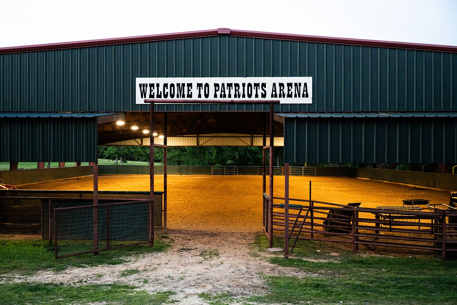 Entrance to Patriots Arena with a welcoming sign and dirt ground.