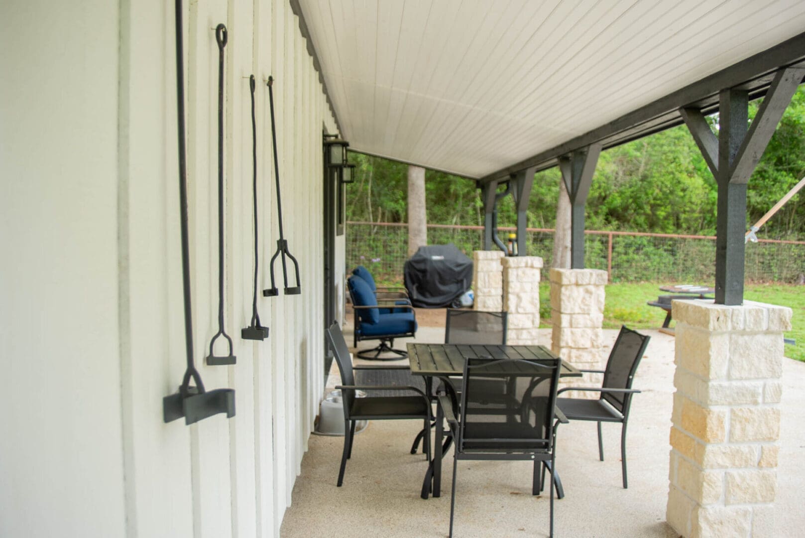Covered patio with table, chairs, and grill